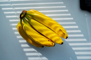 Kitchen aesthetics: a banana gleaming in the daylight - 747594017