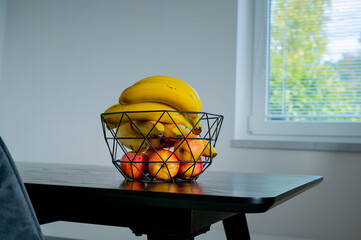 Soft daylight enhances the appeal of a banana in a glass bowl on the kitchen counter. - 747594087
