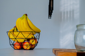 A glass bowl on the kitchen counter cradles a banana in gentle daylight