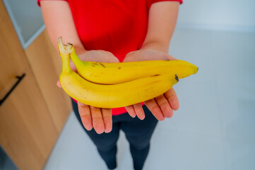 Woman hands holding bananas, natural daylight