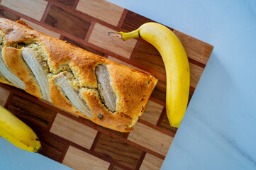 Warm sunlight graces a kitchen setting with banana bread and a fresh banana - 747595289