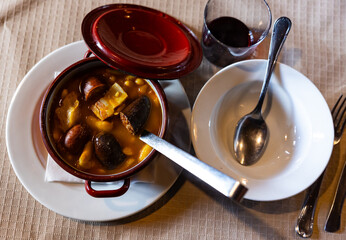 Popular delicious dish of Spanish cuisine is Fabada soup, made from white beans with smoked pork knuckle and Choriso and Morcilla sausage