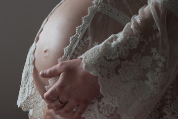 ventre de femme enceinte vue de profil avec dentelle © GLphotographies