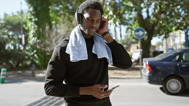 African american man with headphones and smartphone in an urban outdoor setting