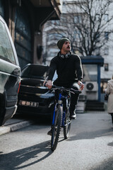 A man in casual wear and a beanie riding a mountain bike on an urban street, symbolizing active lifestyle and eco-friendly transportation.
