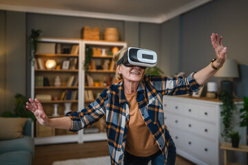 Woman mature senior female at home enjoy virtual reality VR headset