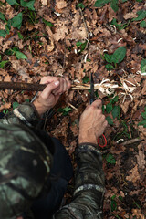 vertical portrait closeup Wilderness Fire Crafting: Survival Technique in Nature with knife