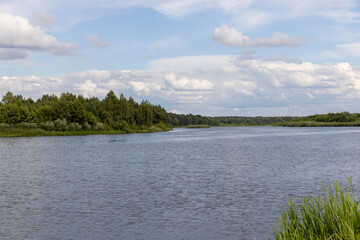 water with waves in the river in summer with green grass