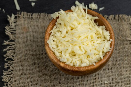 grated cheese for cooking in a wooden bowl in the kitchen