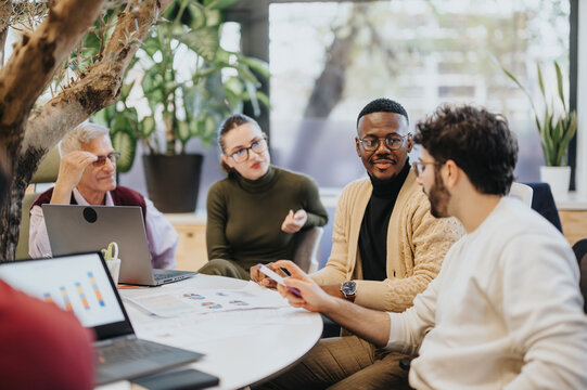 Team strategizing business growth and profitability. Collaborating on market expansion, sales, and marketing success. Effective multi-generational, multiethnic teamwork in the corporate office.