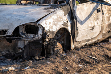 A burned out car. Burnt car in the field. Car fire, vehicle fire due to short circuit. Stolen car...
