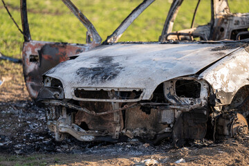 A burned out car. Burnt car in the field. Car fire, vehicle fire due to short circuit. Stolen car...