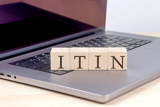 ITIN word on wooden block on laptop, business concept