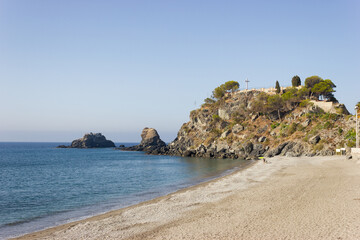 Detail of La Caletilla beach in Almuñecar, Granada, Andalusia with the Rock of the Saint (Peñon del Santo) in the background.