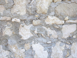 background texture of stone slabs of a sidewalk or wall with seams sealed with cement mortar. blocks of different shapes and sizes are precisely adjusted to each other
