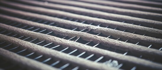 A detailed view of a dirty metal grill on an HVAC system, filled with dust and debris, requiring immediate cleaning and disinfection to prevent allergies and respiratory illnesses.