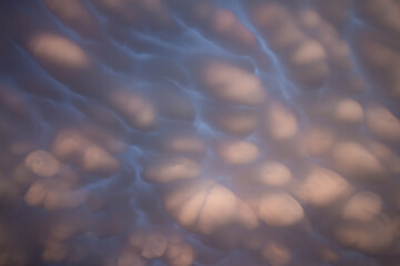 Mammatus clouds in the sky overhead create an other worldly display. Light from the setting sun...