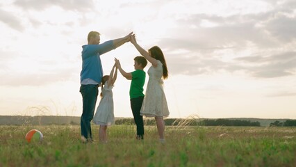 Home symbol, Happy family mom dad daughter, son, kid, dream to build house, mortgage for family. Happy family shows house with their hands, symbol of safety, comfort for child, sunset. Parents child