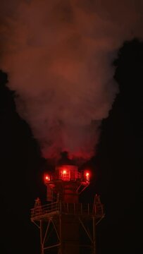 Refinery chimney at extremely cold temperature. Close-up. Night scene