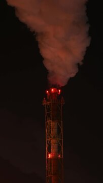 Refinery chimney at low temperature. Night scene