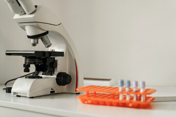 Modern medical research laboratory with microscope and test tubes with biochemicals on the desk