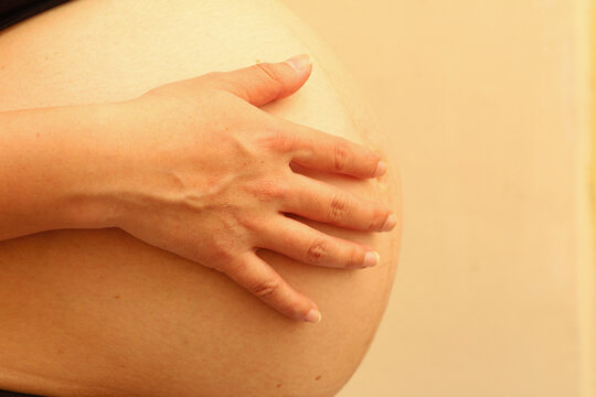 mano de mujer tocando su estomago de embarazo.