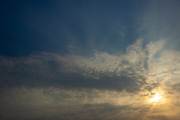 Sunset sky with clouds and rays of light. Nature background.