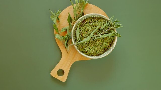 dietary sweetener.crushed stevia leaves cup on a green background.Stevia plant.Alternative Low Calorie Vegetable Sweetener. 4k footage