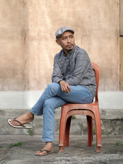 man smoking with a serious expression wearing a suit shirt and flat cap