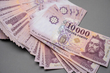 Hungarian banknote bundle money (forint) 10,000 HUF banknotes spread out on a table, close-up as background. Europe Hungary.