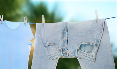 Jeans and t-shirt drying on washing line outdoors, banner design