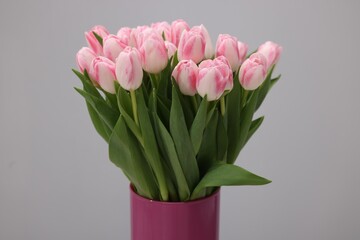 Beautiful bouquet of fresh pink tulips on light grey background