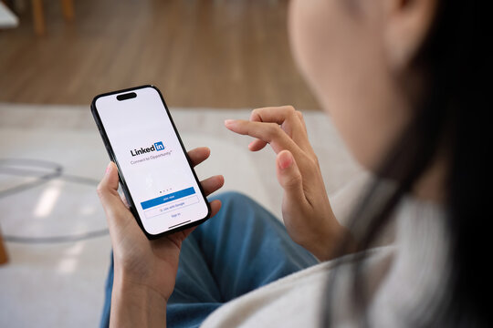 CHIANG MAI, THAILAND, FEB 27,2024 : A women holds Apple iPhone 14 Pro Max with LinkedIn application on the screen.LinkedIn is a photo-sharing app for smartphones.