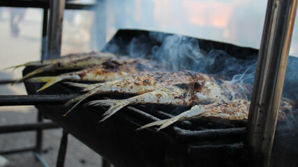 grilling fish on charcoal grill.