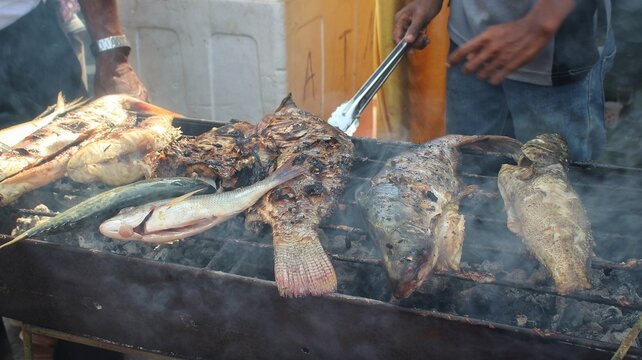 Grilling fish in open air restaurant. Selective focus.