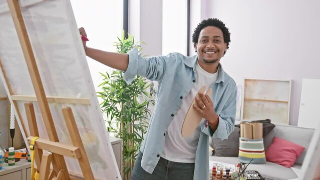 Smiling artist painting on canvas in bright indoor studio, expressing creativity and joy