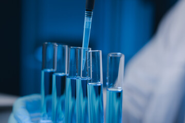 Many test tubes were analyzed by experts, A researcher is carefully studying the liquid contained in a test tube because it is an important area of research.