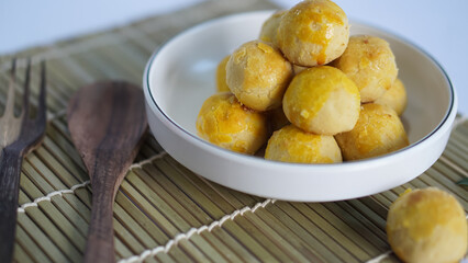 Nastar cookies are round in shape, with a shiny yellow top. Inside it is filled with pineapple jam