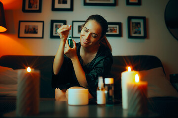Happy Woman Using a Face Serum in her Beauty Routine at Home. Lady enjoying her skin care ritual every night before bedtime
