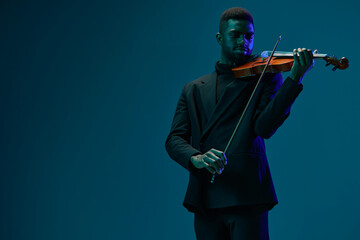 Classically Dressed Man Playing Violin on Blue Background with Copy Space for Musical Performances...