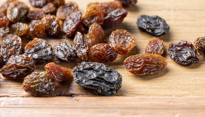 raisins on wooden table background, selective focus (detailed close-up shot)