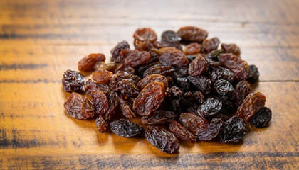 raisins on wooden table background, selective focus (detailed close-up shot)