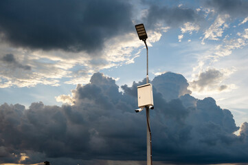 CCTV camera, lamp post isolated on sky background.