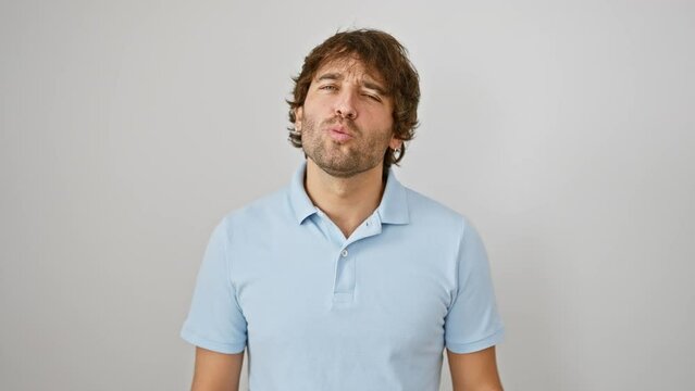 Attractive young caucasian man blowing a love-filled kiss, a funny and charming gesture caught on camera over a clean, white isolated background.
