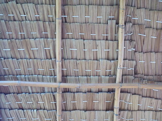 View from the southern side of a traditional thatched roof in a rural village. Use large bamboo trees instead of beams and pillars. That thatched roof can be sunproof and rainproof. And good ventilati