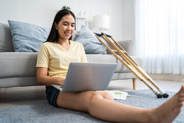 Asian woman amputee using laptop computer, work in living room at home. 