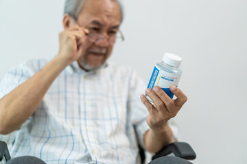 Asian Senior elderly male patient sit on wheelchair at nursing home care. 