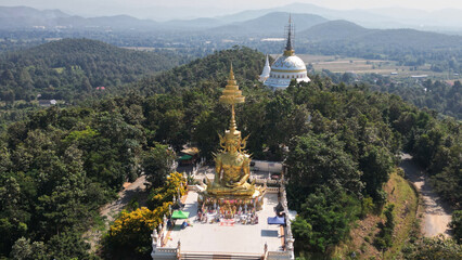 Top view of Phra Maha Jakkaphat in Thai Buddhist art is a large golden Buddha statue sitting outdoors on a hill. Inside Wat Phra That Doi Saket. This temple is another important temple in Thailand.