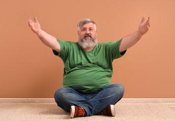 Mature man opening arms for hug near color wall