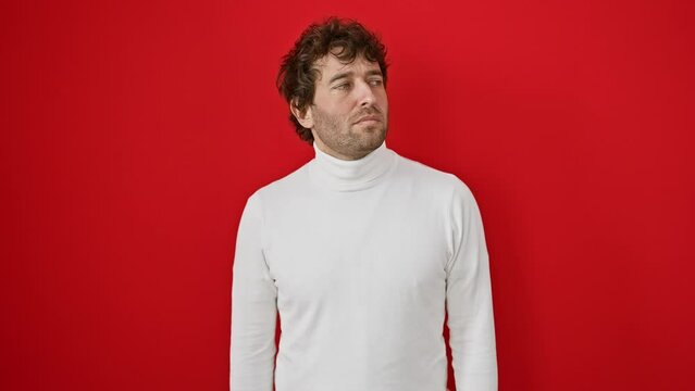 Young hispanic man wearing sweater standing relaxed with serious expression on face. simple and natural looking at the camera. over isolated red background